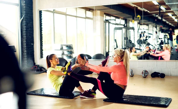 Mujeres haciendo ejercicios de estiramiento en el gimnasio — Foto de Stock