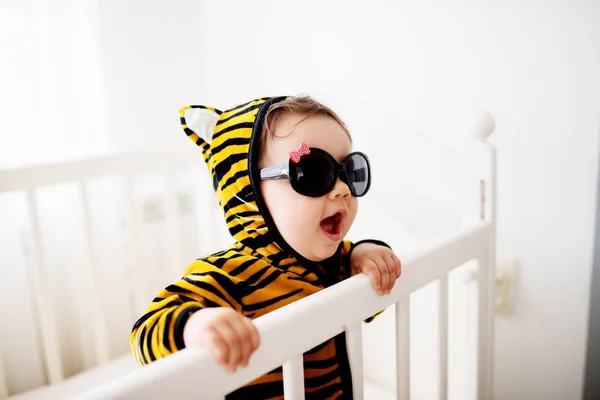 Baby wearing tiger costume in crib. — Stock Photo, Image