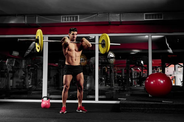 Musculoso hombre haciendo ejercicio en el gimnasio — Foto de Stock