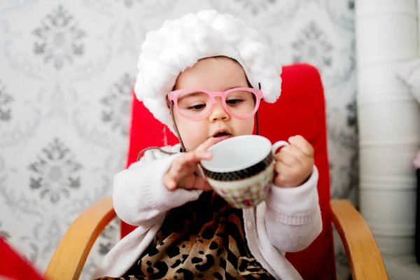 Aranyos baba lány gazdaság teáscsésze — Stock Fotó