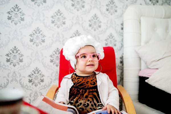 Schattige babymeisje zit in de stoel — Stockfoto