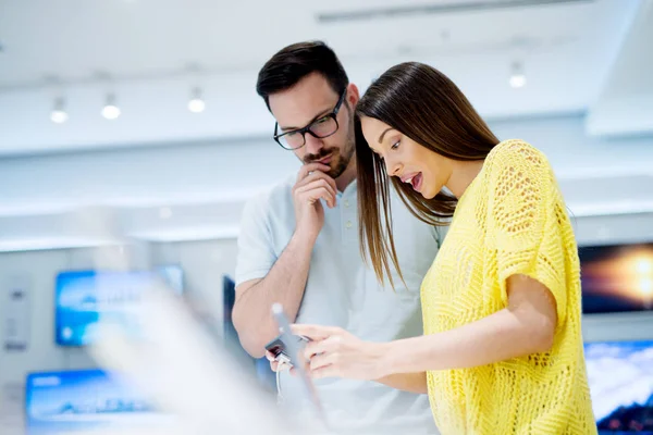 Pareja joven en tienda de electrónica — Foto de Stock