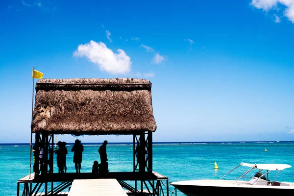 Silhouetten von Menschen, die sich am Meer entspannen — Stockfoto