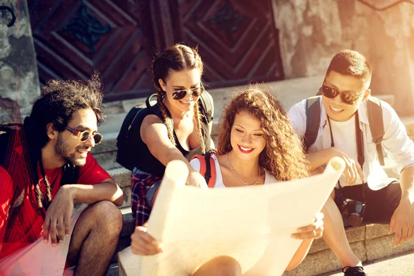 Amigos felices mirando el mapa de la ciudad — Foto de Stock