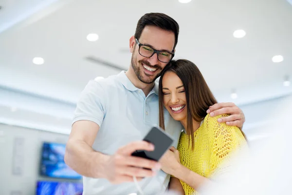 Pareja joven en tienda de electrónica — Foto de Stock