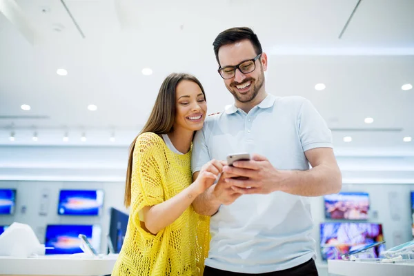 Pareja joven en tienda de electrónica — Foto de Stock