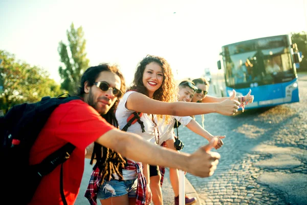 Happy friends hitchhiking — Stock Photo, Image