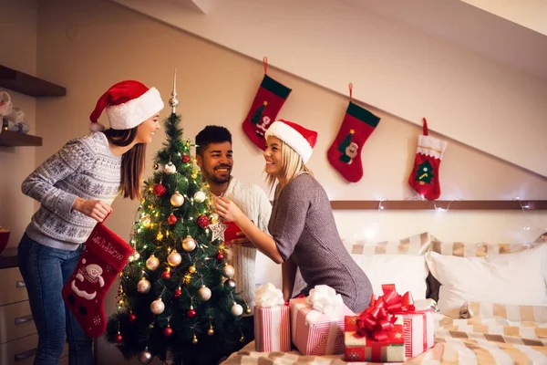 Glada vänner dekorera julgran — Stockfoto