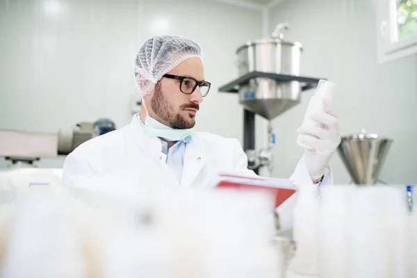 Researcher looking at liquid soap bottle — Stock Photo, Image