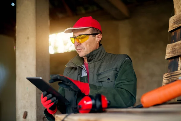 Falegname senior con tablet pc in officina — Foto Stock