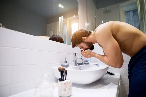 強い筋肉の上半身裸の男のトイレで顔を洗う — ストック写真