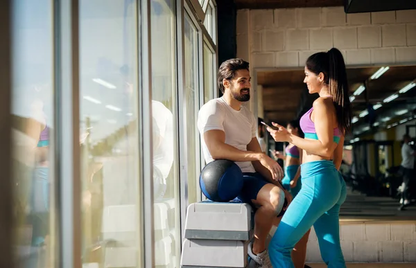 Mulher falando com o homem muscular no ginásio — Fotografia de Stock