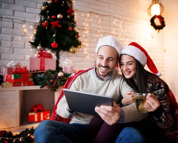 Casal sorrindo com tablet pc no Natal — Fotografia de Stock