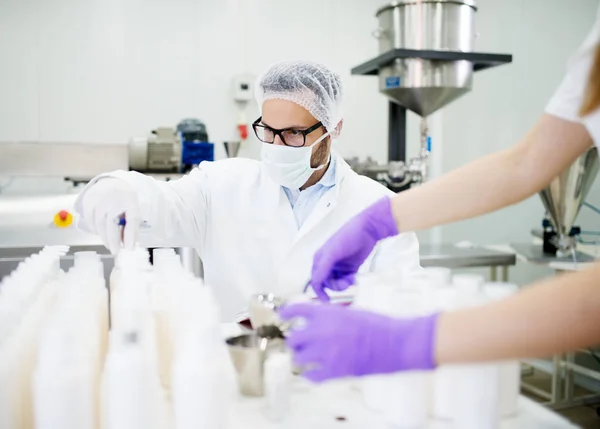 Two Scientists Checking Quality Cosmetic Products Laboratory White Bottles Foreground — Stock Photo, Image