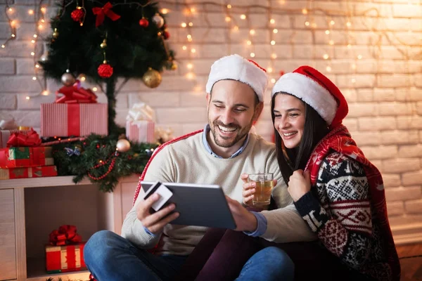 Улыбающаяся пара с планшетным ПК на Рождество — стоковое фото