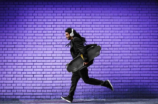 Man with skateboard running on street — Stock Photo, Image