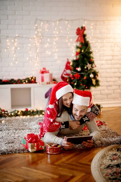 Casal sorrindo com tablet pc no Natal — Fotografia de Stock