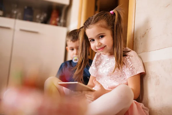 Klein meisje en jongen spelen met tablet — Stockfoto