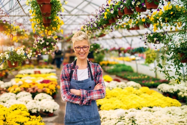 Vrouwelijke tuinman in kas — Stockfoto