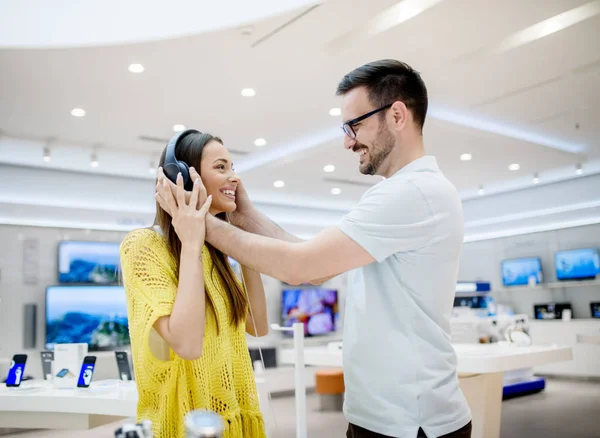 Jovem Mulher Feliz Homem Loja Tecnologia Escolher Novos Fones Ouvido — Fotografia de Stock