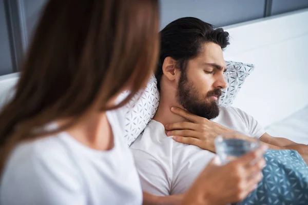 Junger Mann Mit Halsschmerzen Liegt Hause Bett Seine Vorsichtige Freundin — Stockfoto