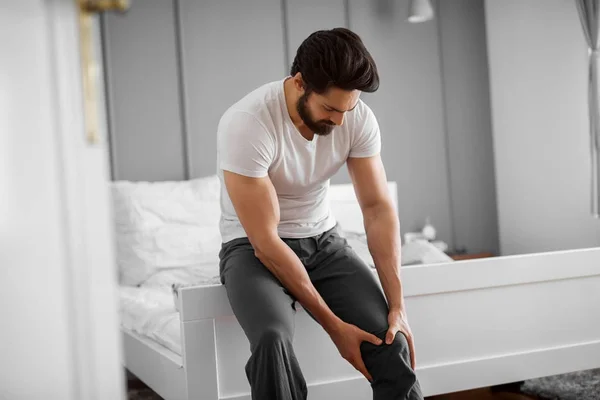 Portrait Sad Handsome Muscular Bearded Man Suffering Knee Pain Home — Stock Photo, Image