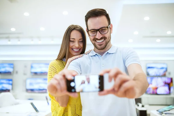 Mladý Šťastný Pár Elektronice Ukládat Výběrem Nový Smartphone Užívat Selfie — Stock fotografie