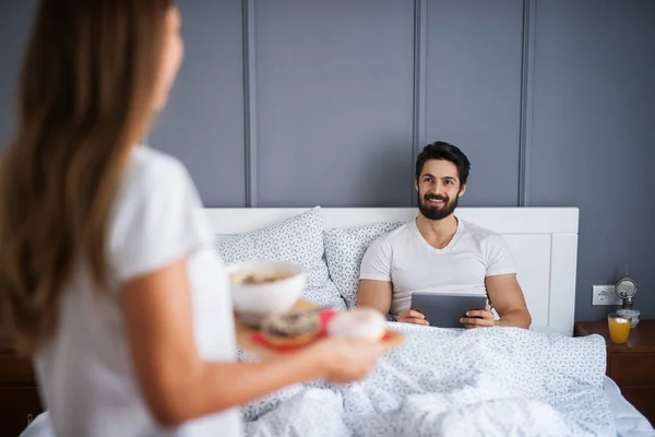 Happy Bearded Man Bed Tablet Girlfriend Bringing Breakfast — Stock Photo, Image