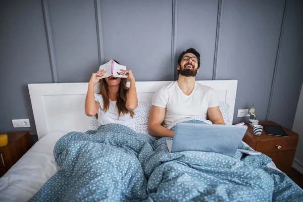 Retrato Jovem Casal Alegre Deitado Cama Rindo Homem Usando Laptop — Fotografia de Stock