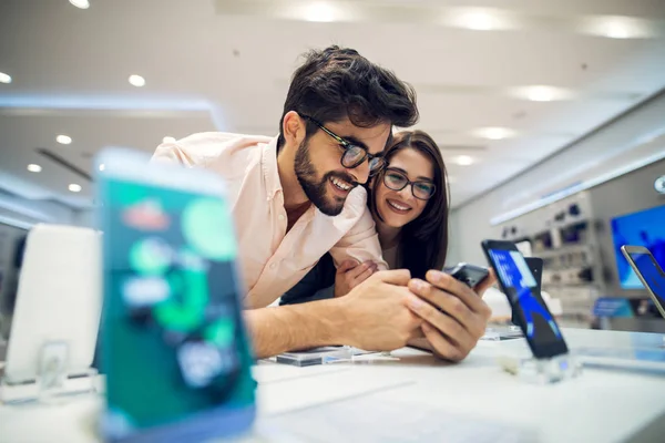 Jovem Casal Feliz Loja Eletrônicos Escolher Novo Smartphone — Fotografia de Stock