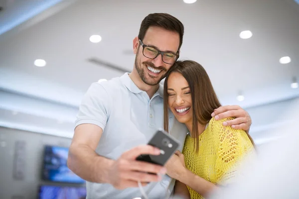 Junges Glückliches Paar Elektronikgeschäft Wählt Neues Smartphone — Stockfoto