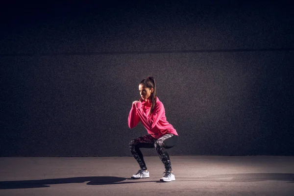 Portret Van Jonge Slanke Vrouw Sportkleding Doen Squats Tegen Donkere — Stockfoto