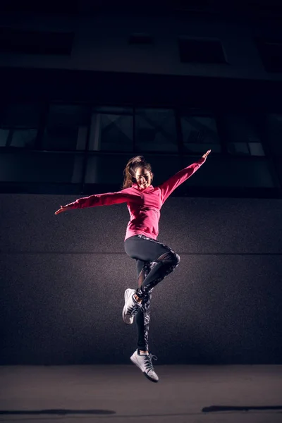 Retrato Mujer Joven Delgada Ropa Deportiva Saltando Contra Pared Oscura — Foto de Stock