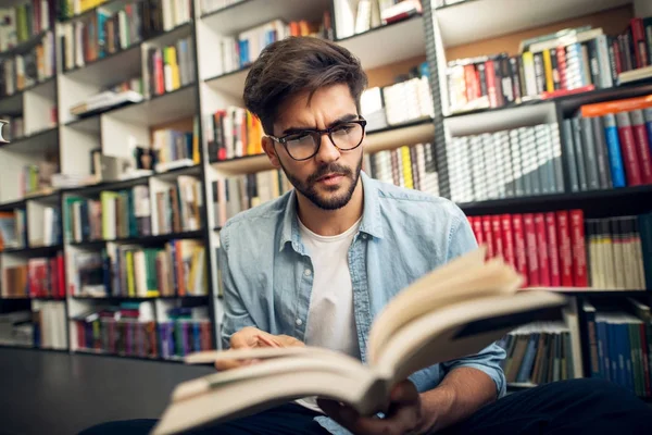 Portrét Mladého Studenta Zamyšlený Čtení Knihy Knihovně — Stock fotografie