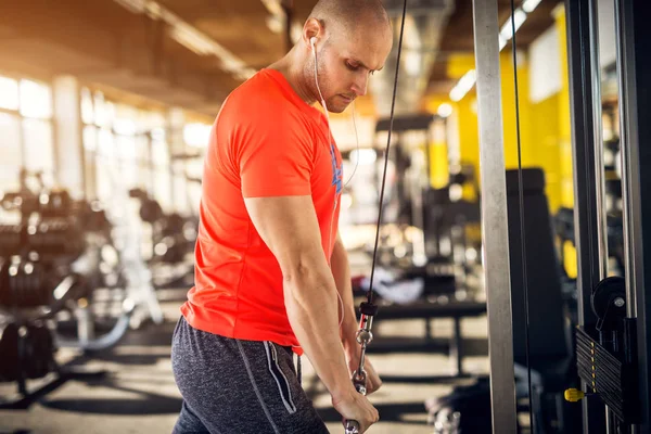 Stark Muskulös Skallig Man Med Hörlurar Gör Triceps Övning Maskin — Stockfoto