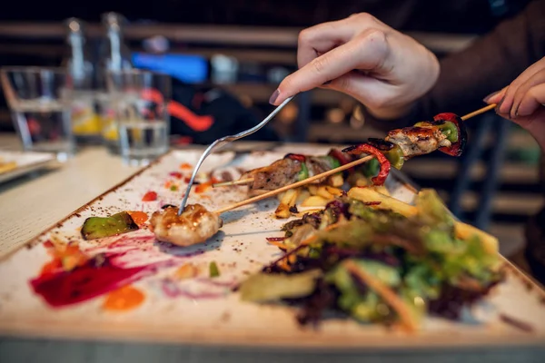 レストランで皿の上おいしい揚げチップとフライド ポテトとサラダを食べる女 — ストック写真