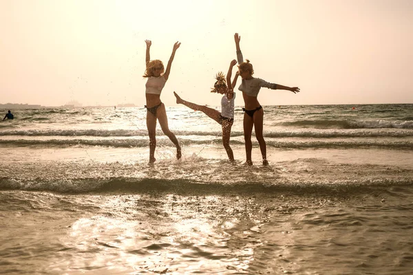 Cuatro mujeres se divierten en la playa — Foto de Stock