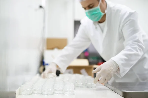 Hombre con guantes preparando crema — Foto de Stock