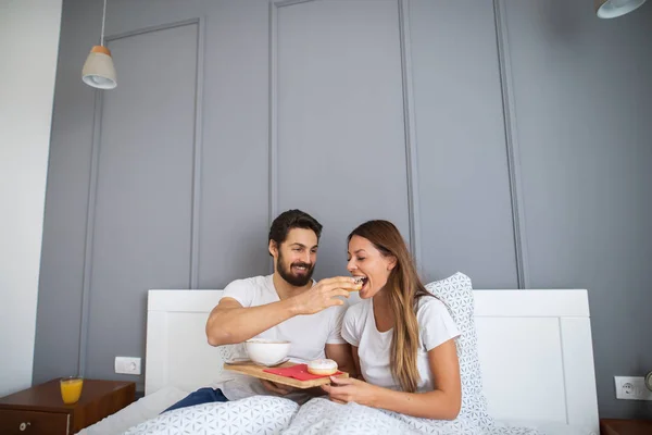 Atractivo Joven Feliz Hombre Alimentación Novia Cama Casa — Foto de Stock