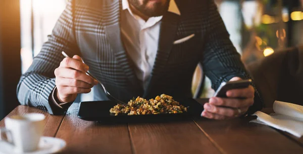 Knappe Zakenman Telefoon Controleren Terwijl Het Eten Van Maaltijd Restaurant — Stockfoto