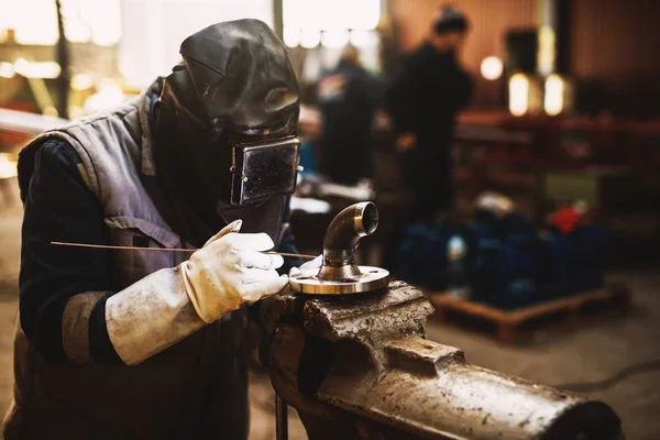 带防护面具的专业焊工在车间工作 — 图库照片
