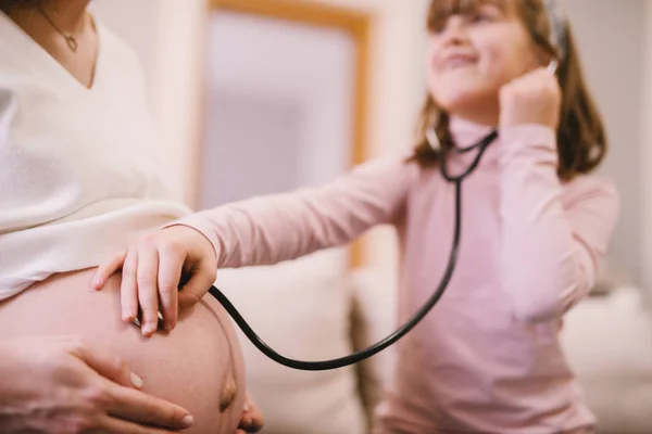 Söta Småbarn Flicka Lyssnande Magen Mamman Gravid Genom Stetoskop — Stockfoto