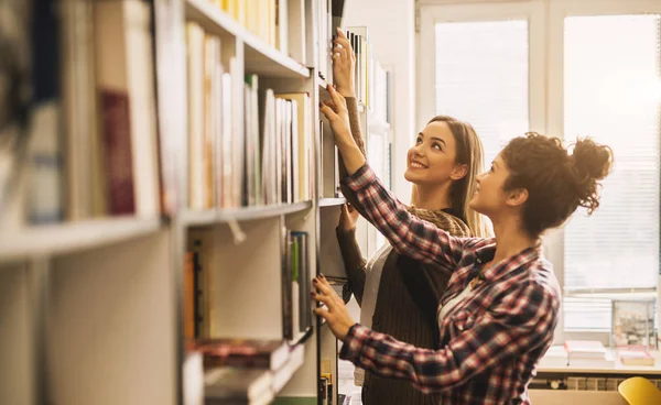 Dwóch Młodych Koleżanki Studiuje Bibliotece Przygotowanie Egzaminu — Zdjęcie stockowe