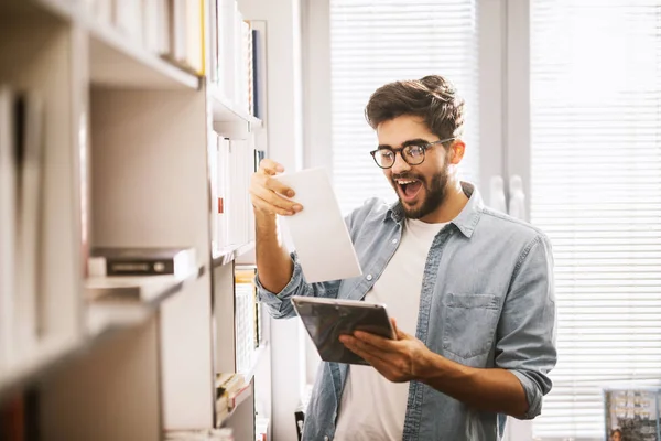 Tablet Kullanarak Kütüphane Içinde Bookshelf Kitap Seçimi Genç Neşeli Yakışıklı — Stok fotoğraf