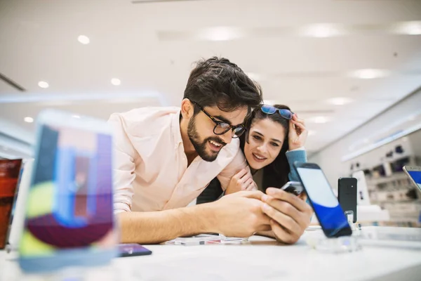 Joven Feliz Pareja Tienda Electrónica Elegir Nuevo Teléfono Inteligente — Foto de Stock