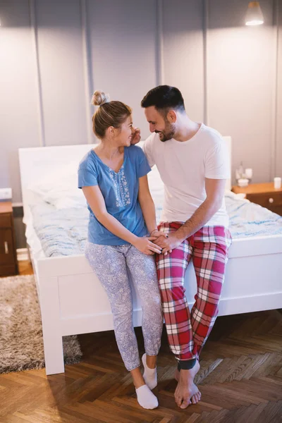 Gelukkige Romantisch Paar Zittend Rand Van Bed Knuffelen — Stockfoto