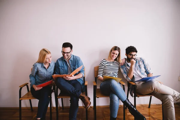 Grupo Jóvenes Sonrientes Confiados Sentados Fila Sala Espera Con Carpetas —  Fotos de Stock