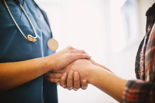 professional nurse holding hands  of female patient in hospital