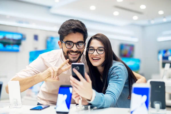 Joven Feliz Pareja Tienda Electrónica Elegir Nuevo Teléfono Inteligente — Foto de Stock