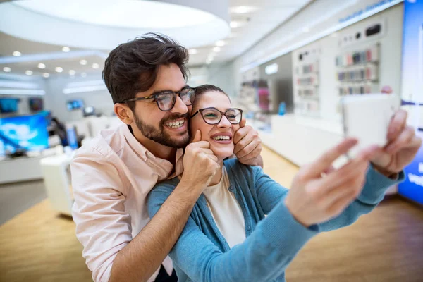 Joven Feliz Pareja Electrónica Tienda Tomando Selfie — Foto de Stock
